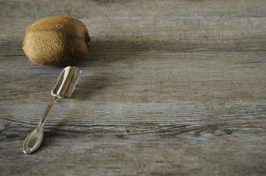 Vintage spoon on old wooden table, country style in low natural light with a brown kiwi