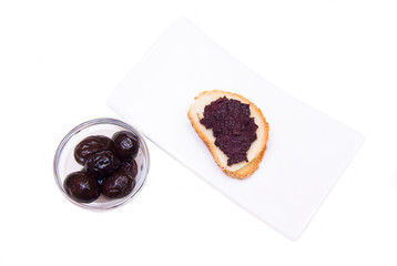 Slice of bread with olive paste on white background view from above