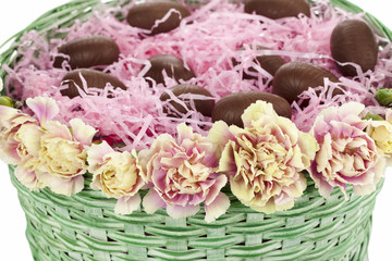 wicker basket with easter eggs and flowers.