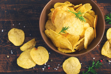 Crispy potato chips with a bowl, top view, tinted