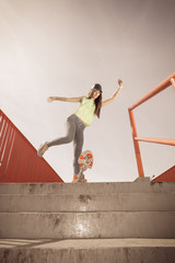 Teen girl skater riding skateboard on street.