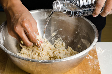 Pouring water into the bowl for mixing dough,bread cooking