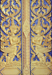 Fototapeta na wymiar Thai temple door golden angle sculpture