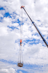 Crane with a cargo with a blue sky background