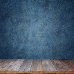 Empty wooden table against a blue wall