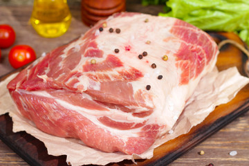 Raw meat. Pork neck with salt and spices on wooden board
