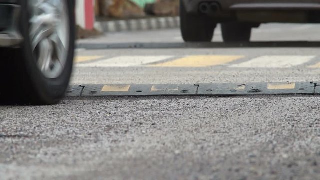 Wheels of the cars jumping over a speed bumps
