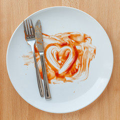 Knife and fork over in finish plate and heart shape ketchup, con