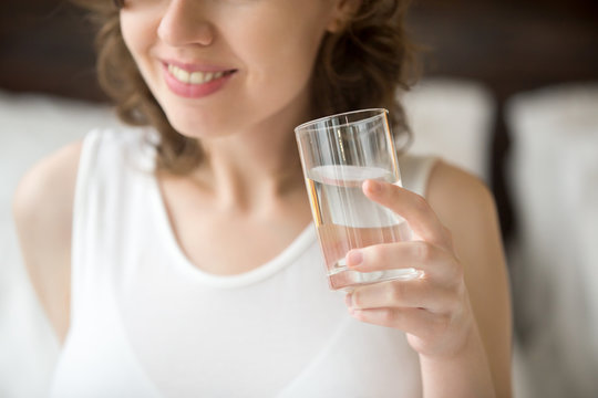 Happy woman holding glass of water