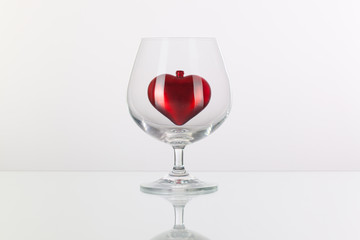 Red heart inside a glass of cognac