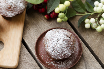 chocolate cupcake with icing sugar on a wooden table