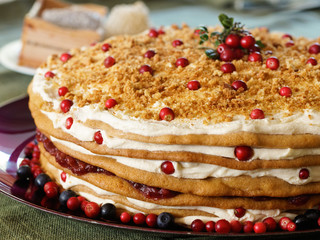Honey cake with sour cream, lingonberries and blueberries