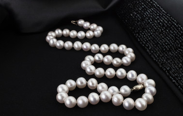 Pearl necklace on black jacket