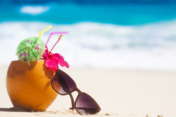 picture of fresh coconut juice and sunglasses on tropical beach