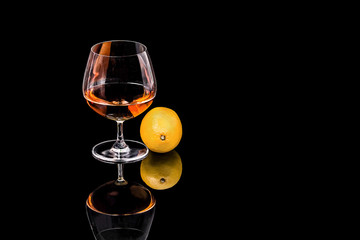 Goblet Brandy and lemon on the black background