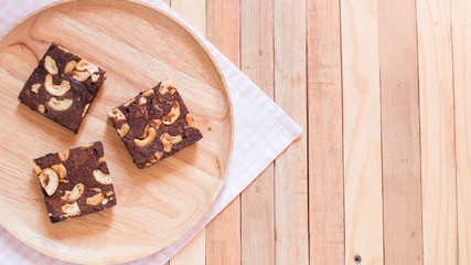 Top view of chocolate brownie cake served on wooden plate.