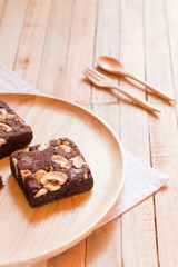 Chocolate brownie cake served on wooden plate.