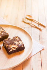 Chocolate brownie cake served on wooden plate.