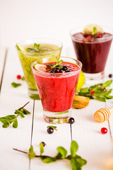 fresh berry smoothies. fruit cocktail with kiwi, currant, cranberry, lime, honey and mint. healthy eating. diet and detox concept.
