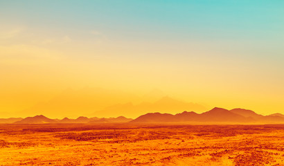 Fototapeta na wymiar African landscape, hot climate in stone desert with silhouettes of hills on the horizon.