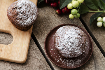 Chocolate cupcakes with icing sugar on a wooden table