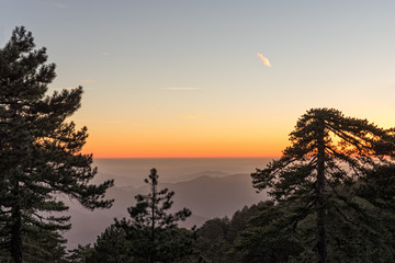 Mountain range with layer mist on evening glow background. Troodos, Cyprus.
