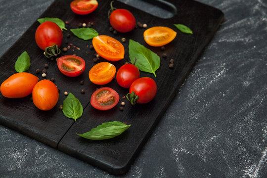Black cutting board with tomato red and yellow