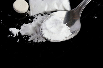 Narcotic drugs on a black surface. Closeup