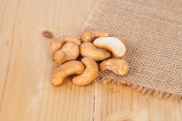 Pile of roasted cashew nuts on wood background