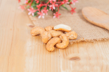 Pile of roasted cashew nuts on wood background