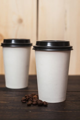 Two white paper coffee cup on the wood table