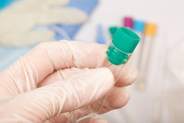 Test tube in the palm of a lab technician. Closeup