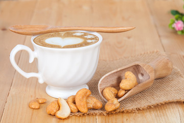 Cashew nuts in spoon, on the wooden