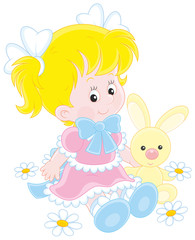 A cute little girl in a beautiful dress sitting with a small toy rabbit among flowers