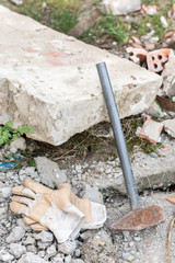 Working gloves with big hammer over ruins