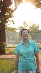 Naklejka na ściany i meble asian senior woman smile in sunshine with morning nature backgro