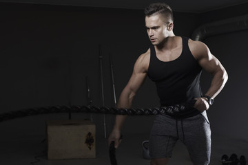 Strong man pulling exercise ropes