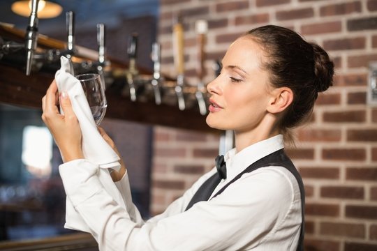 Barmaid cleaning a glass
