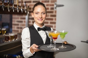 Barmaid holding plate with cocktails