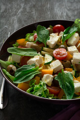 Fresh greek salad with Feta and vegetables on purple plate