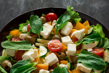 Fresh greek salad with Feta and vegetables on purple plate