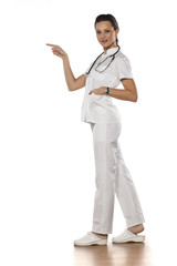 a young woman doctor pointing to the white background