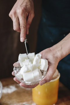 A person using a knife to dice lard for cooking. 