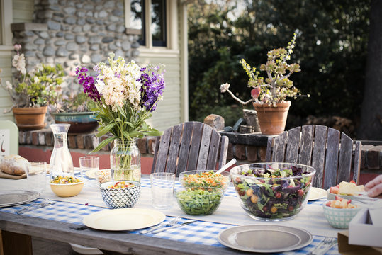 A table set for a meal outdoors in a garden.