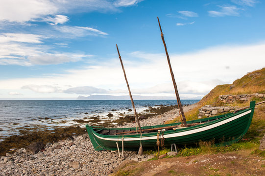 Old fishing boat, boat of the Vikings on the ocean shore, Iceland