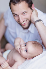 Father and Newborn Son interacting on Blanket Indoors