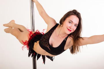 Young sexy pole dancer on white background