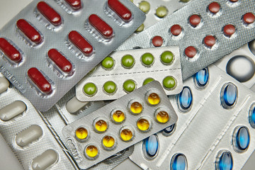 Silver blister packs different colored pills background