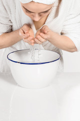 Woman cleaning face in bathroom