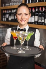 Barmaid holding plate with cocktails